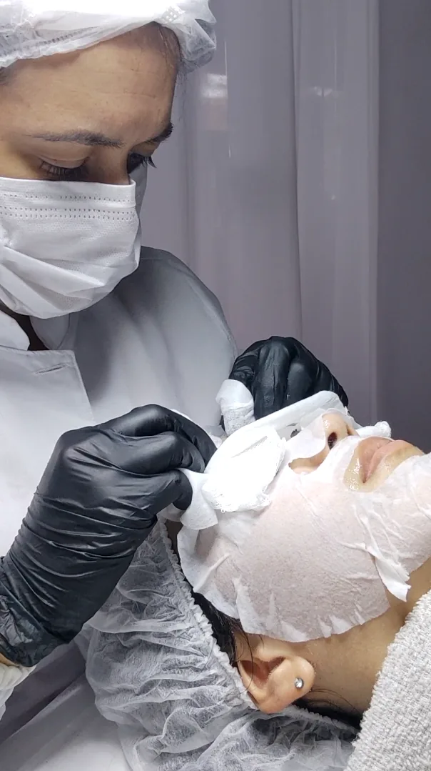 Dra. Paoline removendo a máscara facial de uma paciente na limpeza de pele